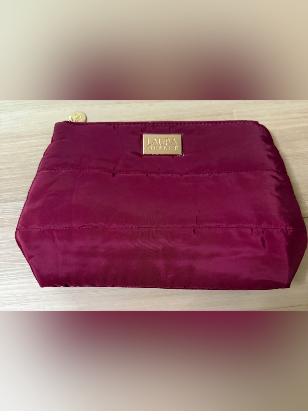 Laura Geller makeup bag in Deep Berry with Gold Logo.  11.5”W - 8”Tall and 3.5”